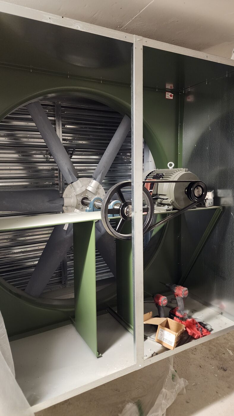 Belt-driven garage exhaust fan inside its housing — the ventilation fan the CO-monitoring system controls.