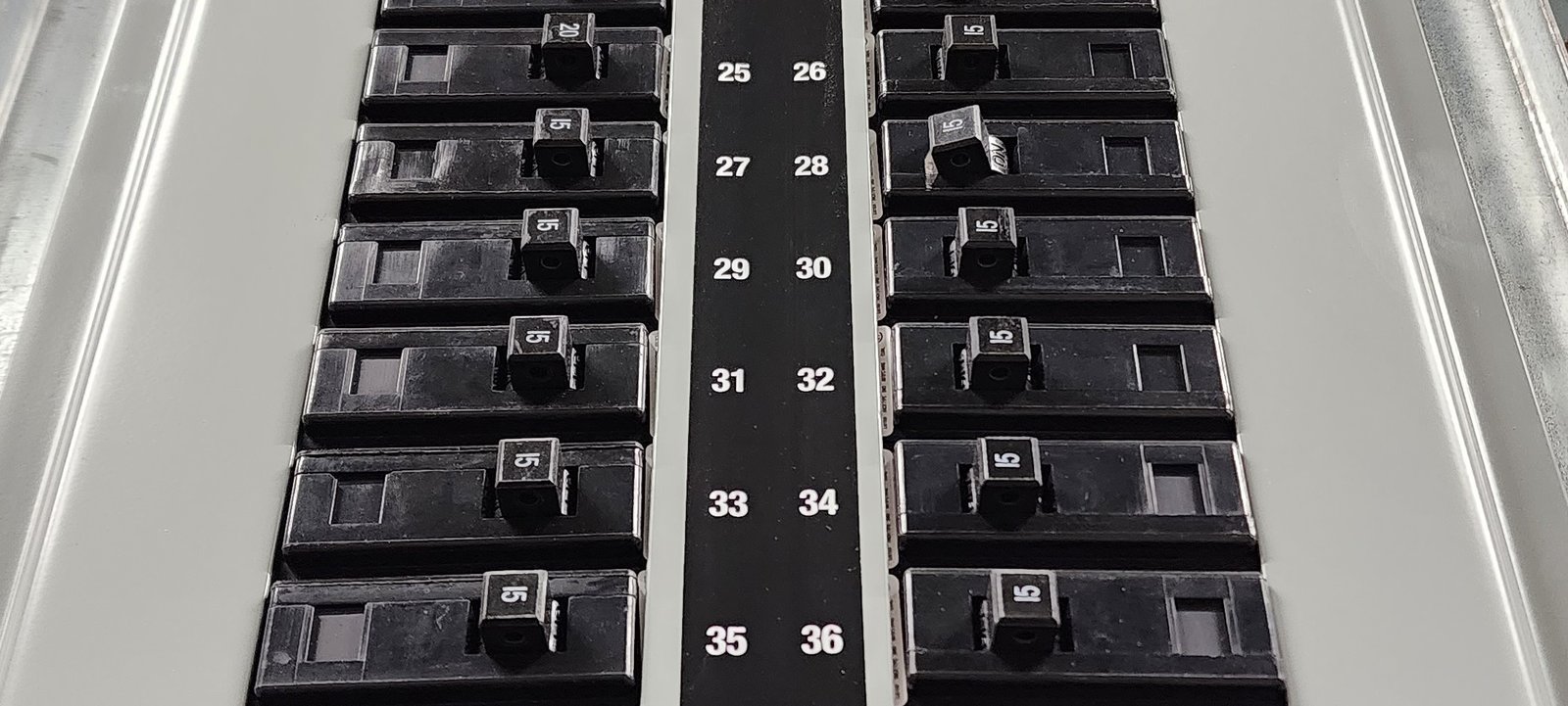 Close-up of a residential electrical panel showing breaker slots and capacity