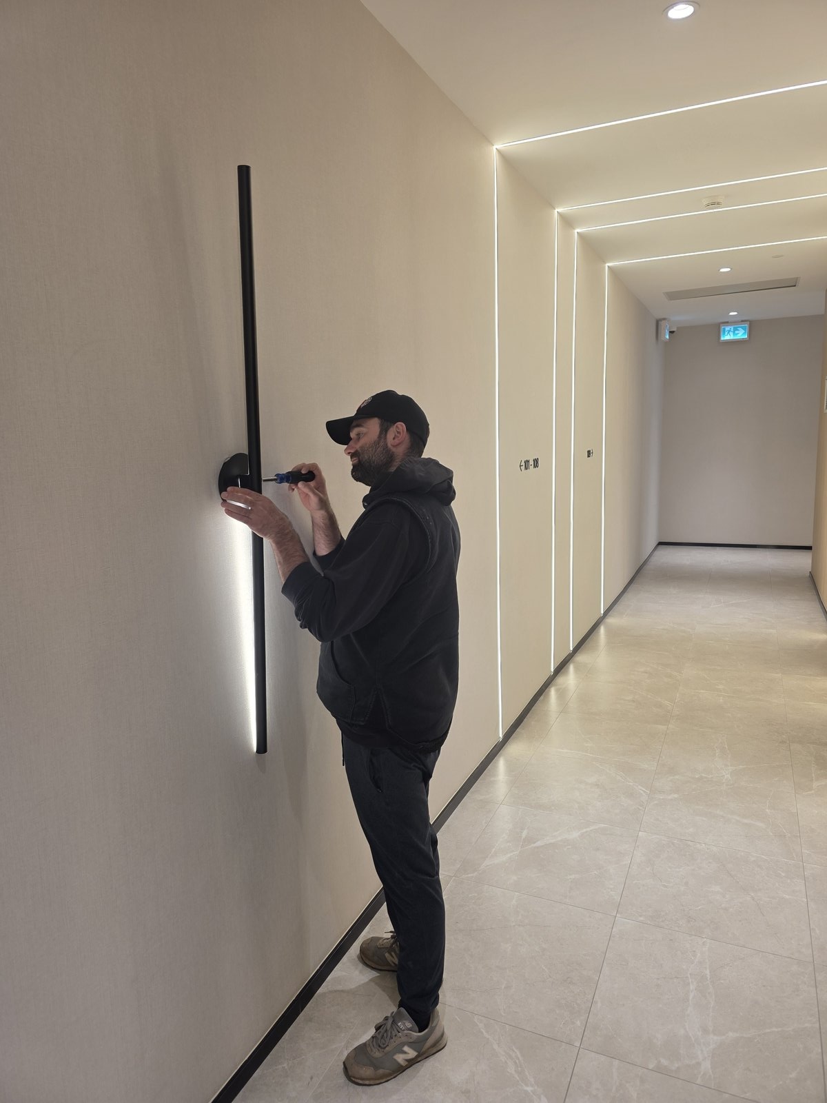 Electrician repairing common area lighting in a residential building by Actus Electric